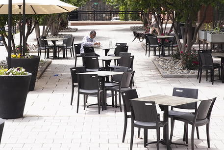 epa08453079 A lone individual eats in the outdoor dining area of a restaurant in Washington, DC, USA, 29 May 2020. The nation's capital begins lifting some restrictions that have been in place for nearly two months that were issued to mitigate the spread of the coronavirus COVID-19 pandemic. Restaurants in Washington, DC, may provide outdoor seating provided tables are six feet apart, in addition to other restrictions that will remain in place. Some businesses will remain closed.  EPA/MICHAEL REYNOLDS