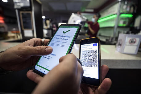 A visitor's Covid-19 Green Pass is checked at the entrance to a bar in Rome, Italy, 09 August 2021. Effective from 06 August, the so-called Green Pass is advocated by the government as the alternative to lockdowns in the light of the spreading Delta variant of the Sars-Cov-2 pandemic coronavirus. People who do not hold the certificate that identifies them as either immunised, recovered or tested for Covid-19 may be excluded from indoor venues and for access to amusement parks it is necessary to be up to date with anti-covid-19 vaccinations, or have a negative swab in the last 48 hours.
ANSA/ANGELO CARCONI