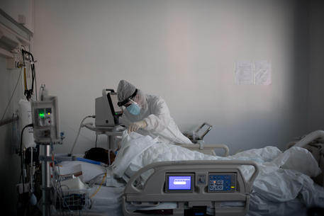 Operatori sanitari, che indossano tute protettive mediche e mascherine, al lavoro nella  terapia intensiva dell'Ospedale Sant'Orsola di Bologna, 12 novembre 2020.  Ansa/Max Cavallari