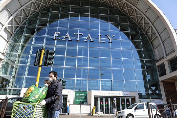 People covering their face with masks at the entrance of Eataly high-end Italian food emporium in Ostiense neighborhood, Rome, Italy, 7 April 2020. ANSA/RICCARDO ANTIMIANI