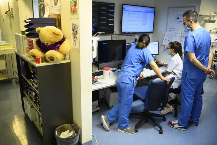 epa09652585 Medical workers brief each other in the pediatric emergencies unit at the hospital 'Reseau hospitalier neuchatelois (RHNe)' Pourtales site during the fifth wave of the coronavirus disease (COVID-19) pandemic in Neuchatel, Switzerland, 21 December 2021.  EPA/LAURENT GILLIERON