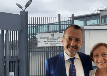 Delmastro e Meloni; sullo sfondo, il carcere di Foggia