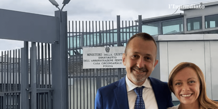 Delmastro e Meloni; sullo sfondo, il carcere di Foggia