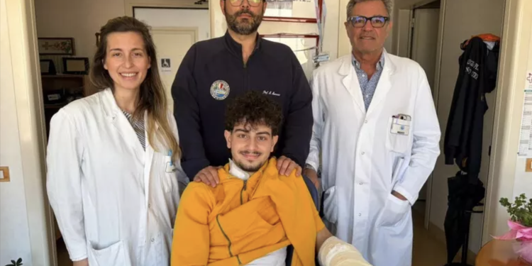 Ragazzo di 18 anni con equipe medica del Policlinico di Bari dopo intervento di microchirurgia alla mano