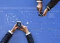 Business people syncing data by mobile phones